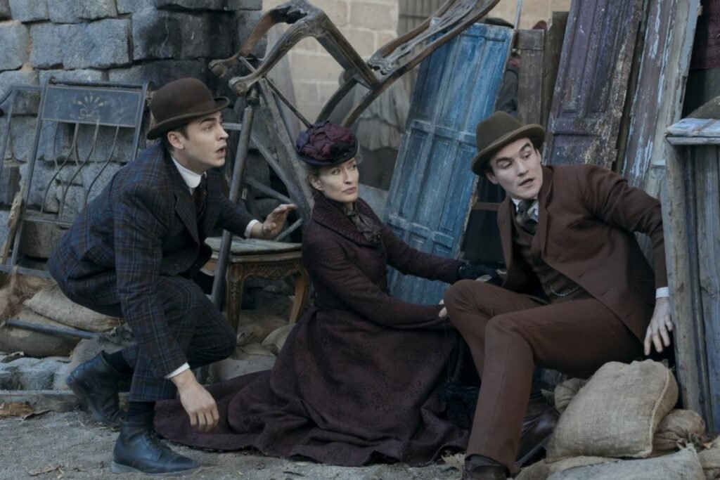 Hero Fiennes Tiffin, Natascha McElhone, and Donal Finn ducking for cover in Prime Video's Young Sherlock.