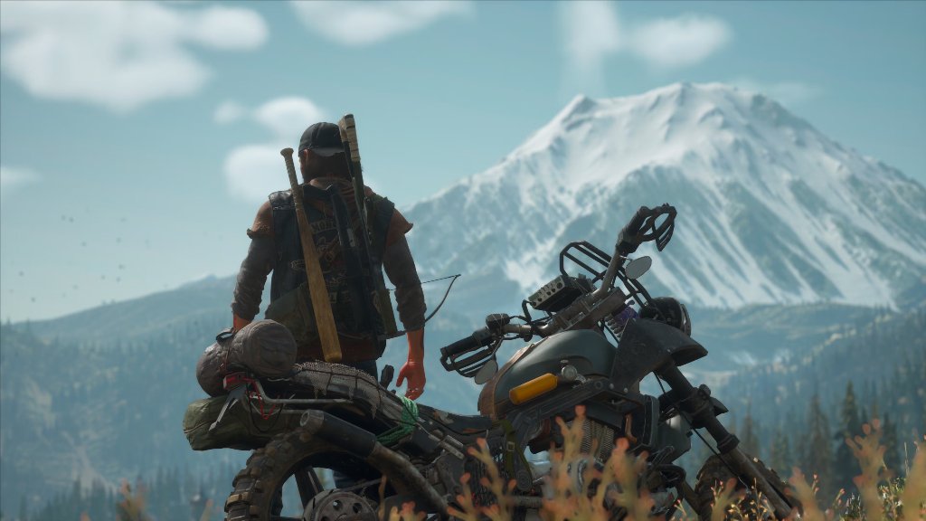 Deacon leans on his motorcycle overlooking a mountain vista in Days Gone.