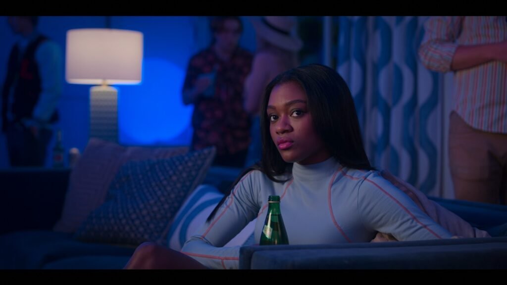 Calliope in First Kill sat on a sofa dressed in all blue.