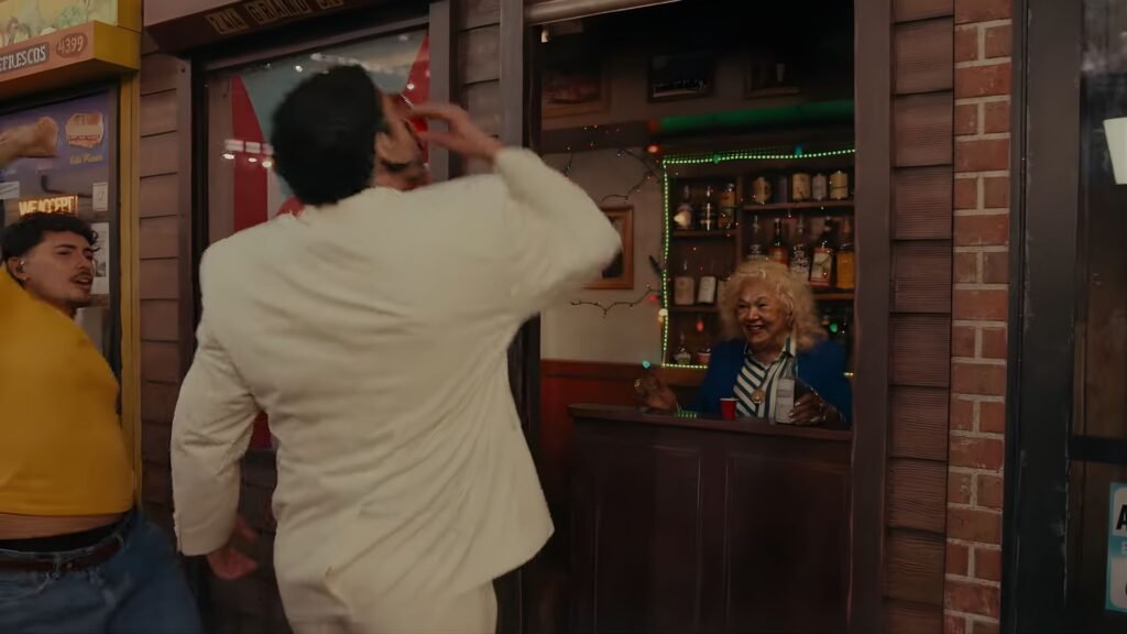 Bad Bunny taking a shot with Maria Antonia Toñita Cay in a replica of Brooklyn Caribbean Social Club bar during Super Bowl halftime