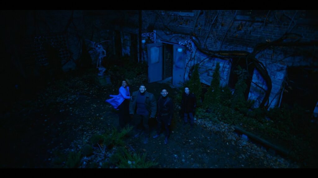 Four siblings in The Umbrella Academy stood outside in the dark surrounded by blue light.