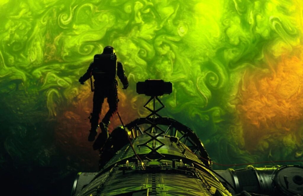 A still from Project Hail Mary. Ryland Grace is hovering above the planet Adrian.